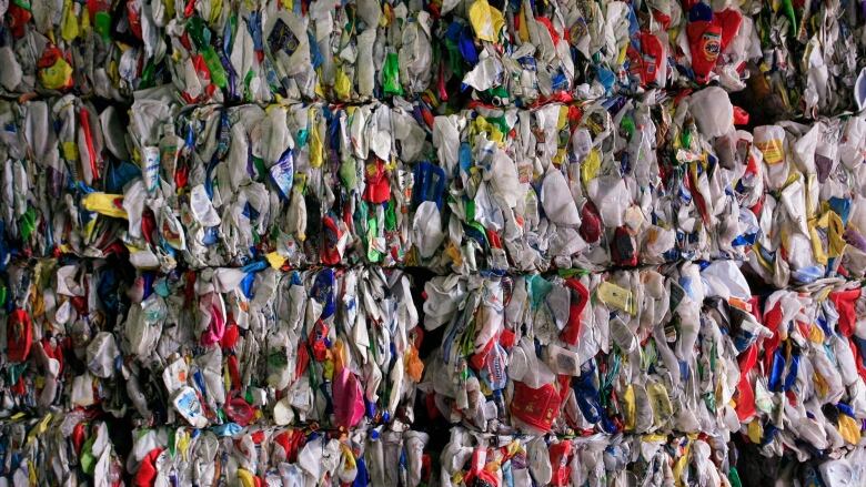 Bales of plastic waste sit in stacks.