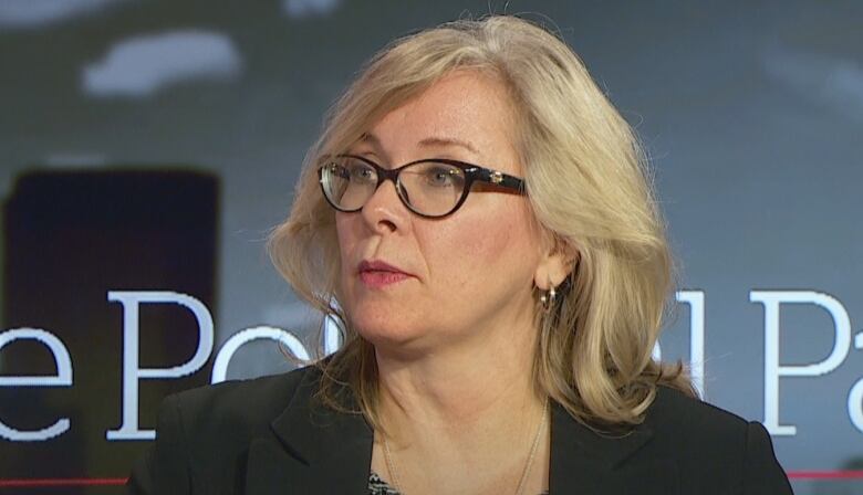 A blond woman in glasses speaks on the set of CBC Calgary's political panel.