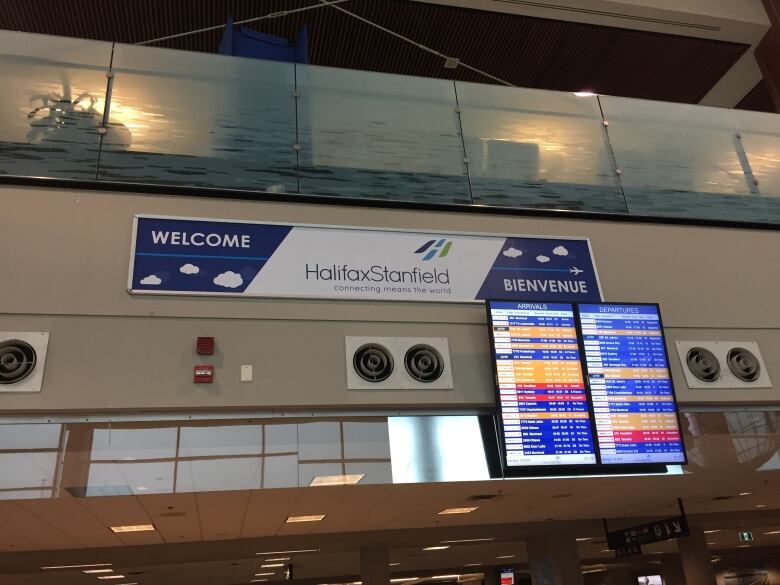 A sign reads Halifax Stanfield next to a board showing flight statuses. 