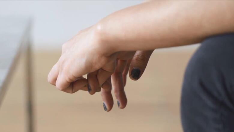 A person's hands resting on their knees