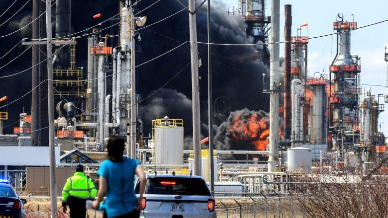 Thick black smoke can be seen coming out an oil refinery.