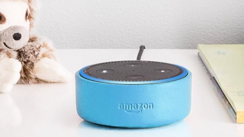 A blue oval shaped speaker on a table with the word Amazon engraved on it