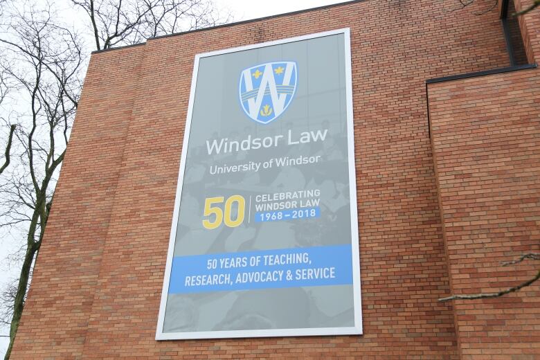 A brick wall with a banner for the University of Windsor law school