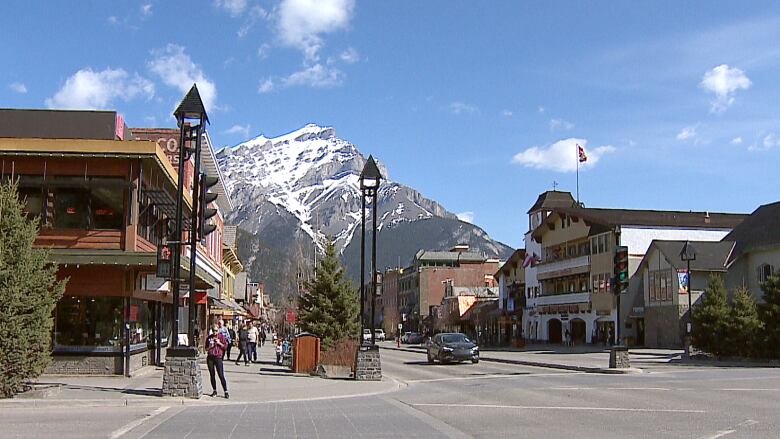 A street view of the town of Banff. A large mountain can be seen in the background. 