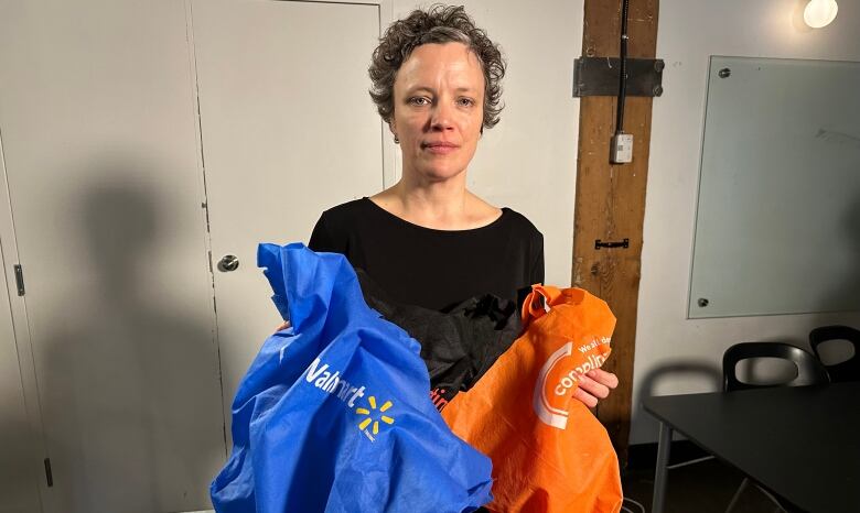 Emily Alfred holding two reusable bags.