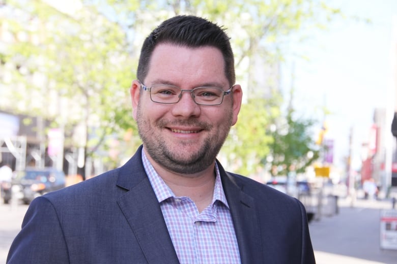 A man smiles for a photo.