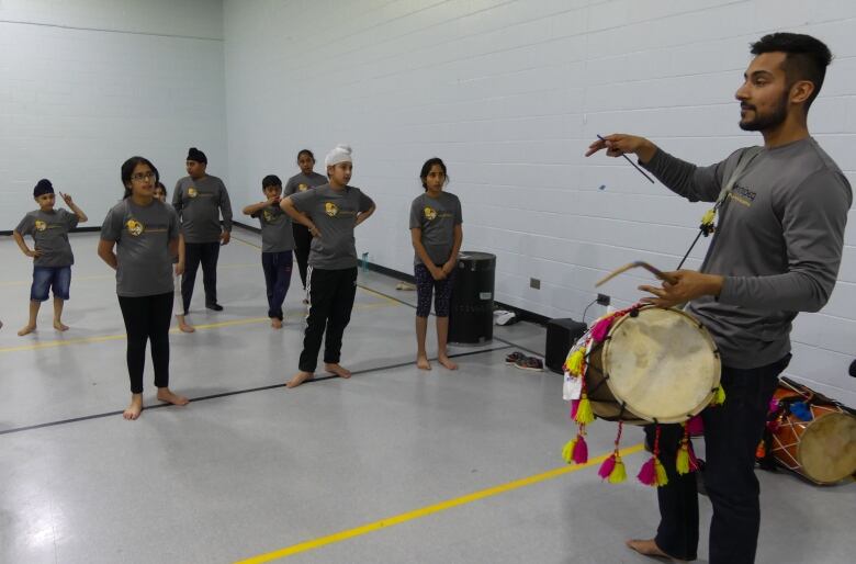 A man with a drum in front of students.