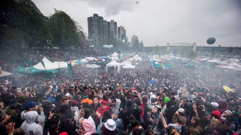 A cloud of smoke hangs over the crowd as thousands of people smoke marijuana during the annual 4/20 marijuana celebration in Vancouver on April 20, 2018.