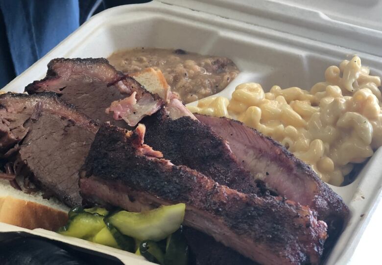 A close-up of meat in a takeout container