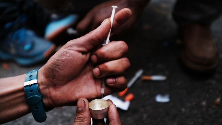 NEW YORK, NY - OCTOBER 07:  A heroin user prepares to shoot up on the street in a South Bronx neighborhood which has the highest rate of heroin-involved overdose deaths in the city on October 7, 2017 in New York City. Like Staten Island, parts of the Bronx are experiencing an epidemic in drug use, especially heroin and other opioid based drugs. More than 1,370 New Yorkers died from overdoses in 2016, the majority of those deaths involved opioids. According to the Deputy Attorney General, drug overdoses are now the leading cause of death for Americans under the age of 50.  (Photo by Spencer Platt/Getty Images)