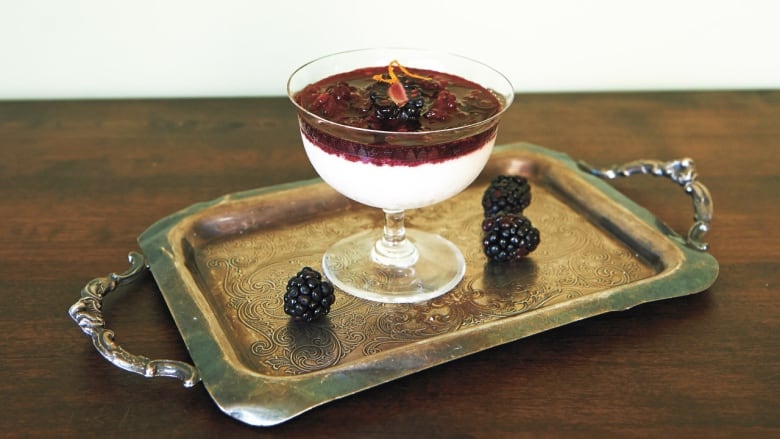 white pudding in a glass coupe with berry compote on top