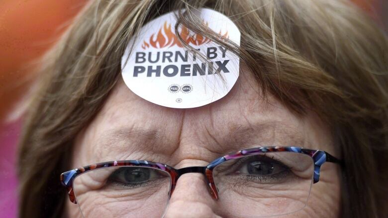 A woman wears a sticker on her forward that says 