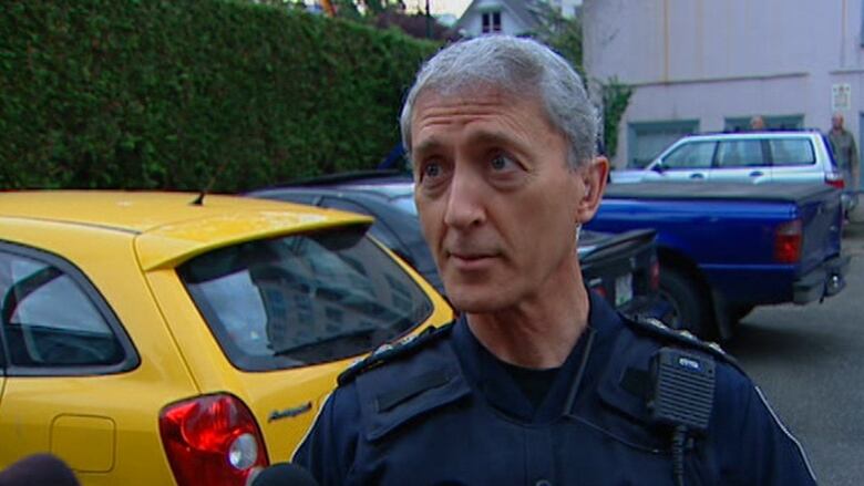 A man wearing a police uniform pictured in a parking lot.