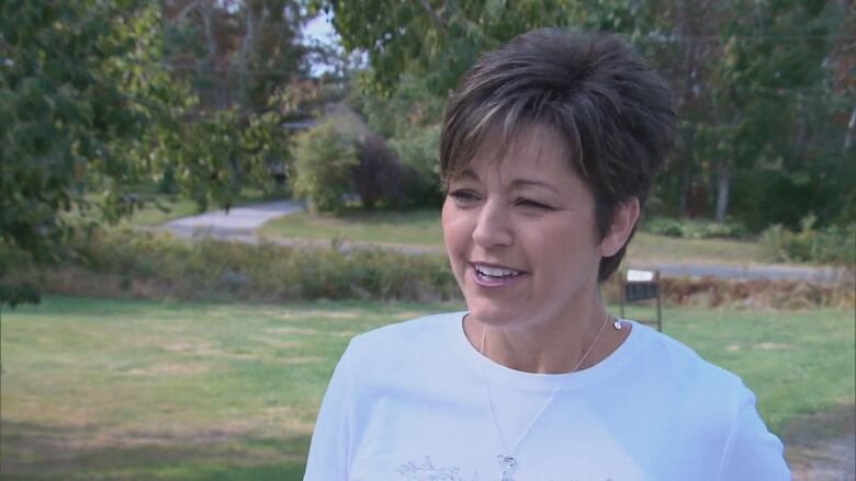 Michelle Conroy speaks while standing outside.