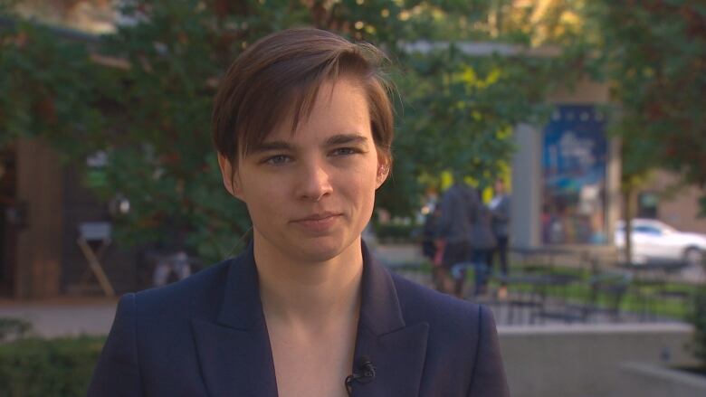 A woman with short hair looks at the camera.