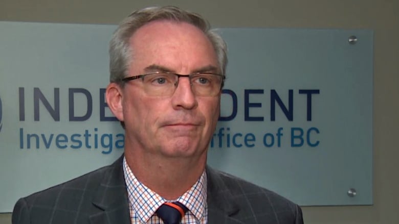 A white man speaks in front of a sign reading 'Independent Investigations Office of BC'.