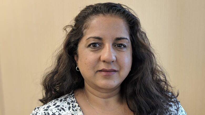 A portrait of a smiling woman in a blouse.