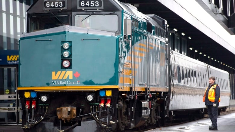 A VIA Rail employee stands on the platform next to a F40 locomotive at the train station in Ottawa on December 3, 2012. 