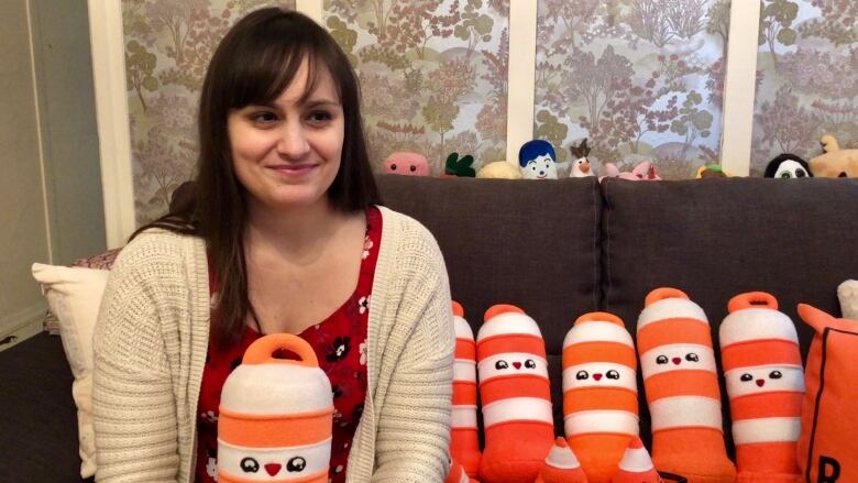 A woman holds a cone plush toy. 