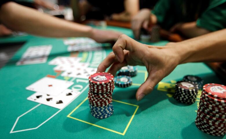 A person reached for chips during a poker game. 