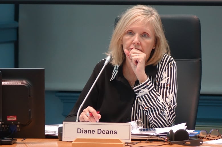 A blond woman in a black and white blouse