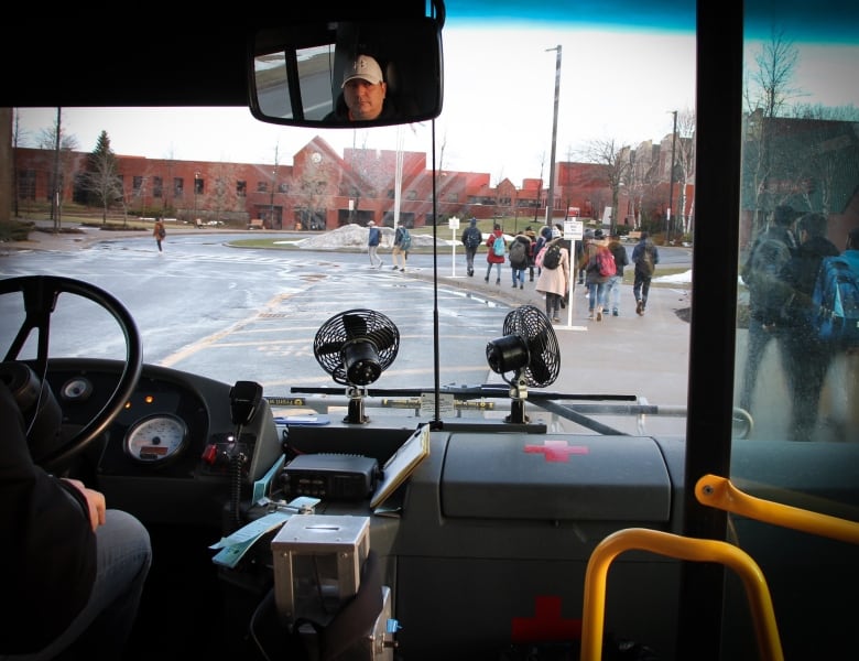 Students get off a bus at Cape Breton University.