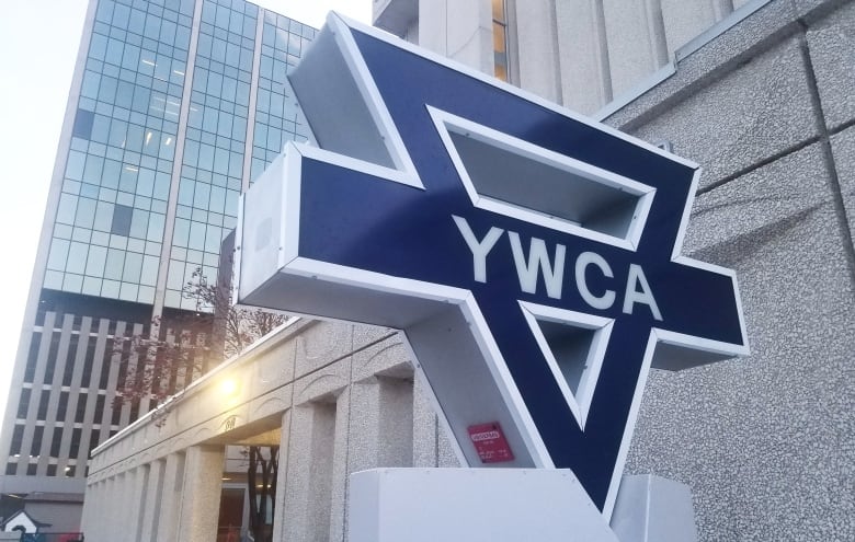 A sign marking the YWCA stands outside a building in downtown Regina.