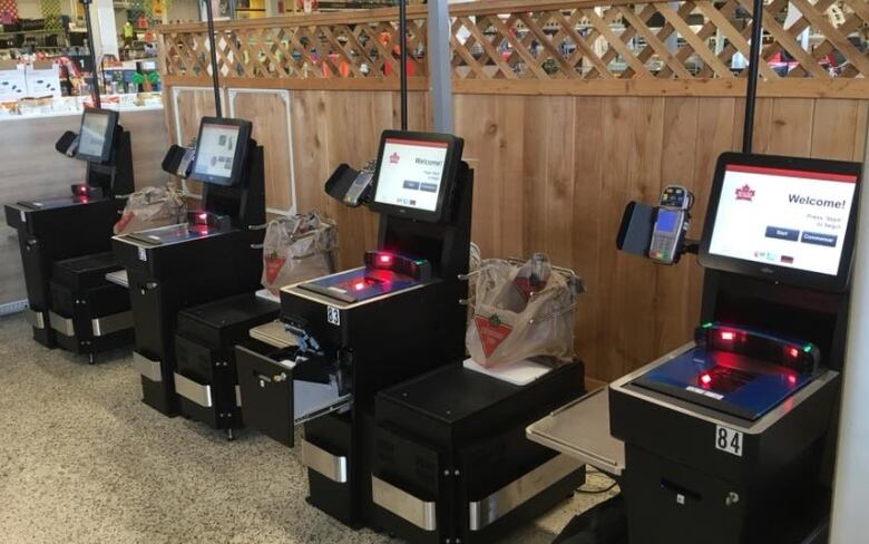 Self-checkout machines lined up in a Canadian Tire store