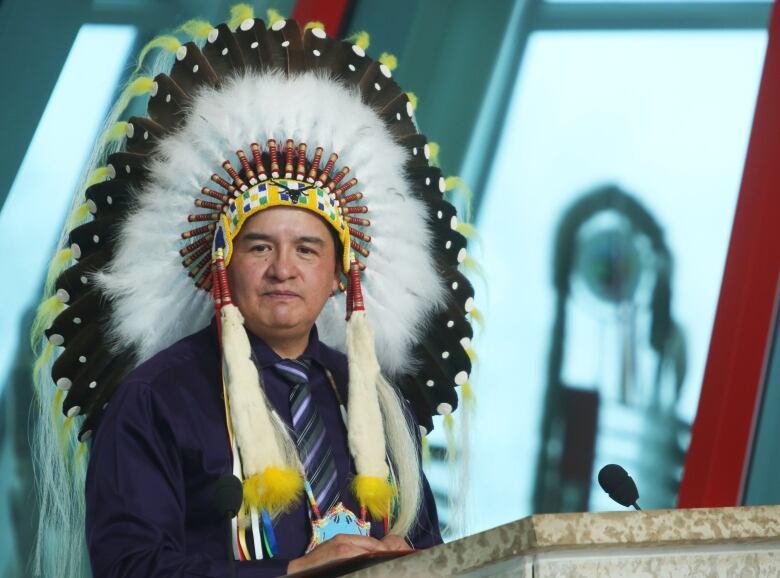 Man addresses crowd in Indigenous attire