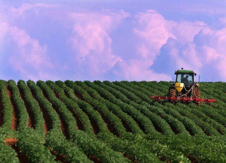 A tractor in front of a colourful sky