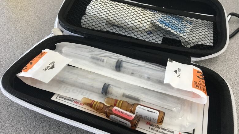 A kit containing two vials of naloxone, two syringes and alcohol swabs.