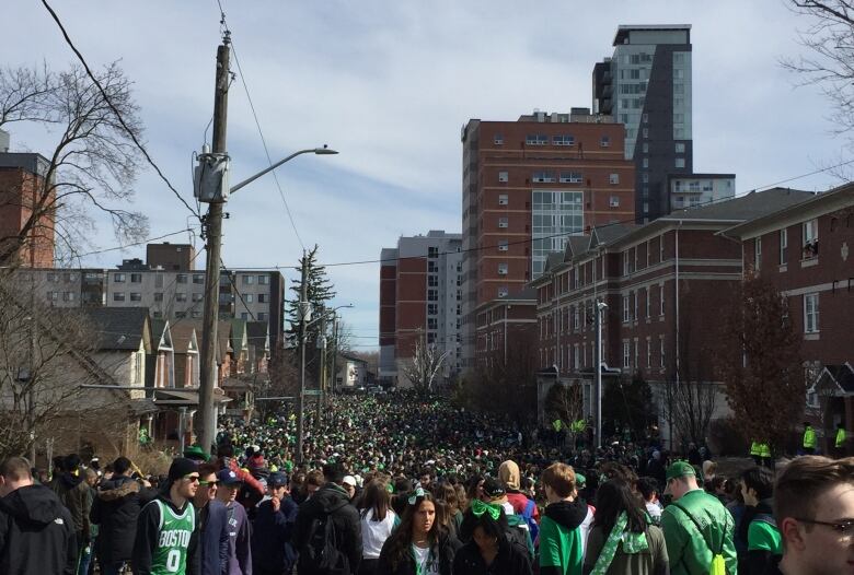 Crowds of students pack the corners of Ezra Avenue as Waterloo Regional Police officers watch for St. Patrick's Day on March 17, 2019