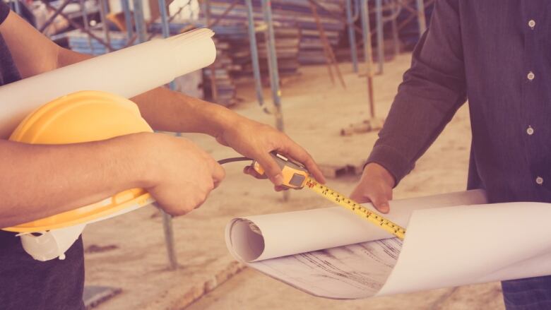 Construction workers talk on a site in this stock image.