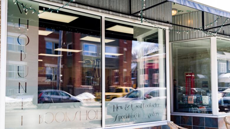 The outside of a storefront showing books in the window. 