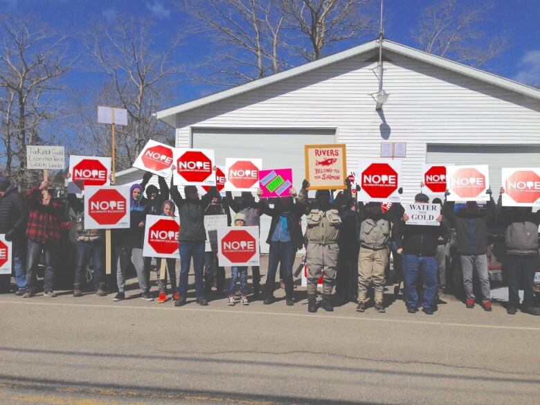 People holding up signs that say 