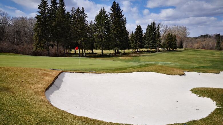 A green and sand bunker on a golf course in early spring in Edmonton. 