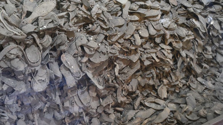 Thousands of old shoes and soles are piled high  