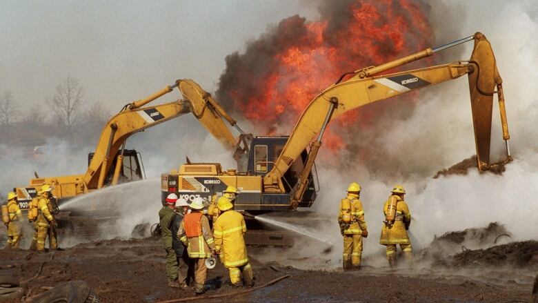 Firefighters battle a tire fire