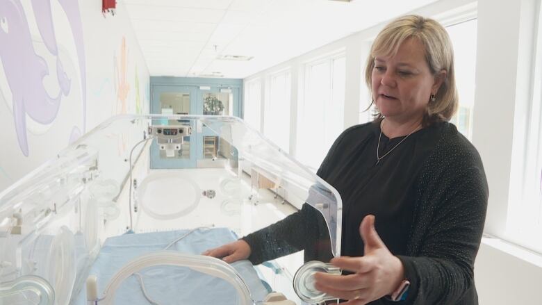 Woman with baby incubator. 