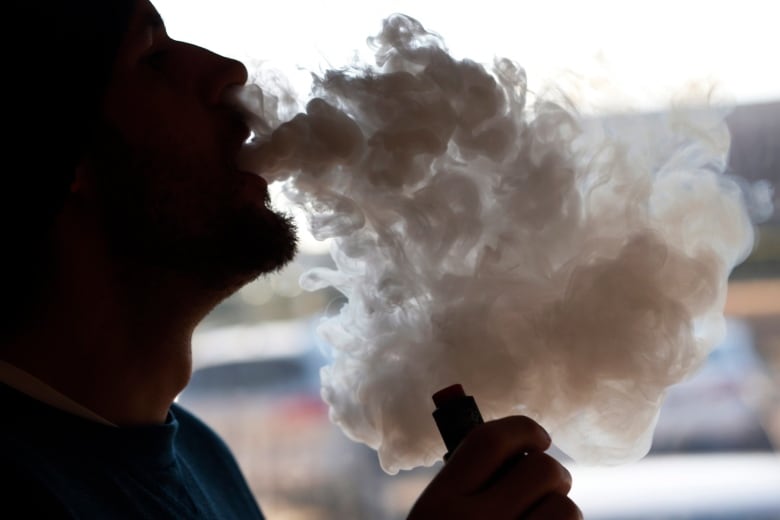 A man exhaling vape smoke is pictured.