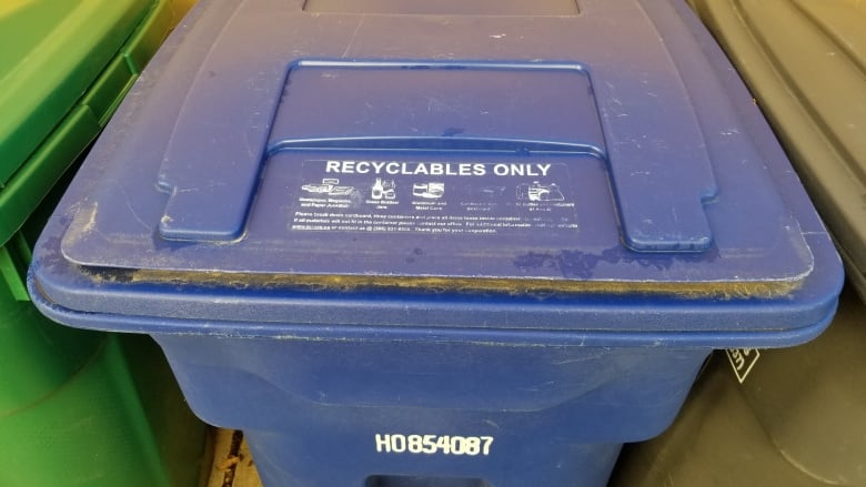 A close-up shot of a blue recycling bin.