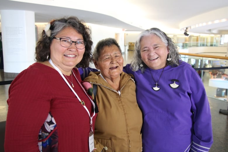 Three Inuit women standing and smiling next to each other