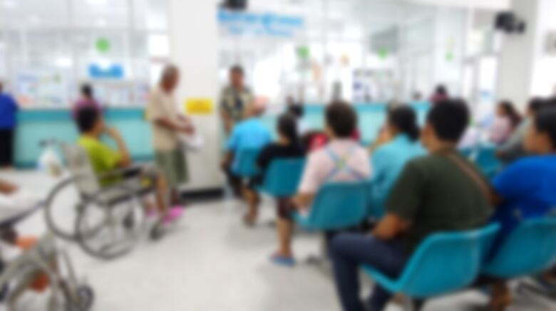 A blurred image of a busy hospital waiting room.