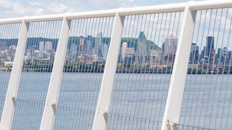 View of Montreal skyline through bridge fencing.