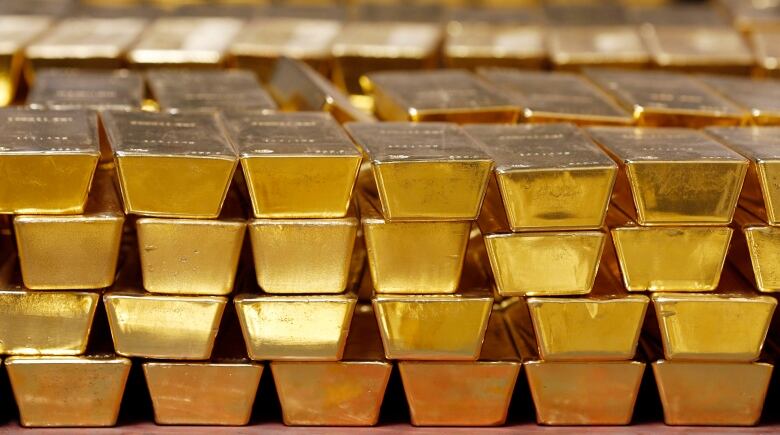 FILE - In this Tuesday, July 22, 2014, file photo, gold bars are stacked in a vault at the United States Mint, in West Point, N.Y. The price of gold has climbed recently as investors scramble for safety amid the widening global trade war. Its up nearly 5% since May 21, 2019, as stock markets around the world fell, and last week was the best of the year for gold after President Donald Trump surprised markets by threatening to raise tariffs on Mexico. (AP Photo/Mike Groll, File)