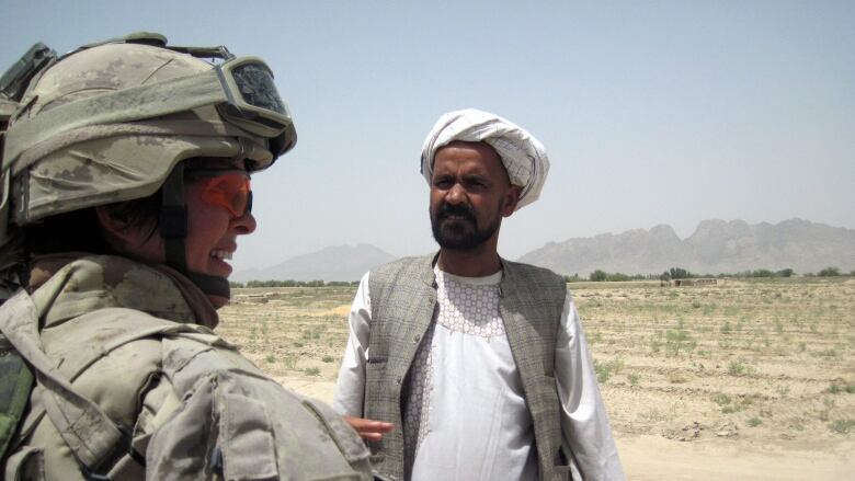 Lt.-Col. Jennie Carignan, commanding officer of the Engineer Regiment of Canada's Task Force Kandahar, speaks to area resident Yar Mohammad about a retaining wall project near his village along the Tarnak River in the Dand Distrct of Kandahar province on August 12, 2010.