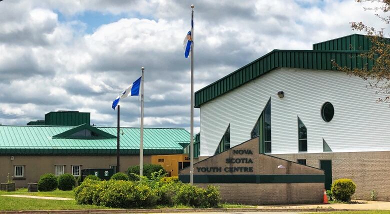 Flags fly outside a building with a sign that reads Nova Scotia Youth Centre.