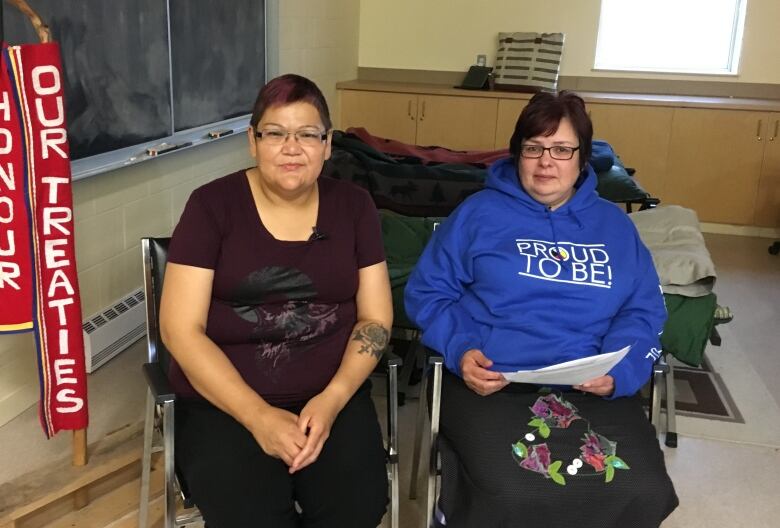 Two women sitting in chairs.