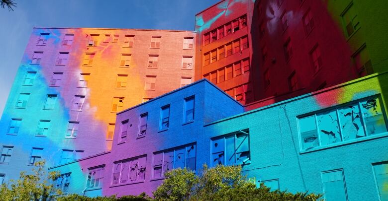 A large building is covered in colourful paint 