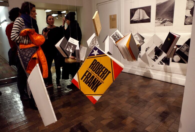 Copies of books by photographer and filmmaker Robert Frank hang from the ceiling at the opening of an exhibition featuring his work, 